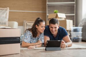 couple planning decoration line with tablet moving home living room young couple moving new apartment